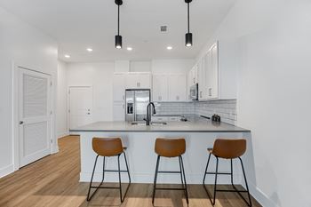 a kitchen with a large island with three stoolsat Oak Grove at Blake Farm, North Carolina, 28411